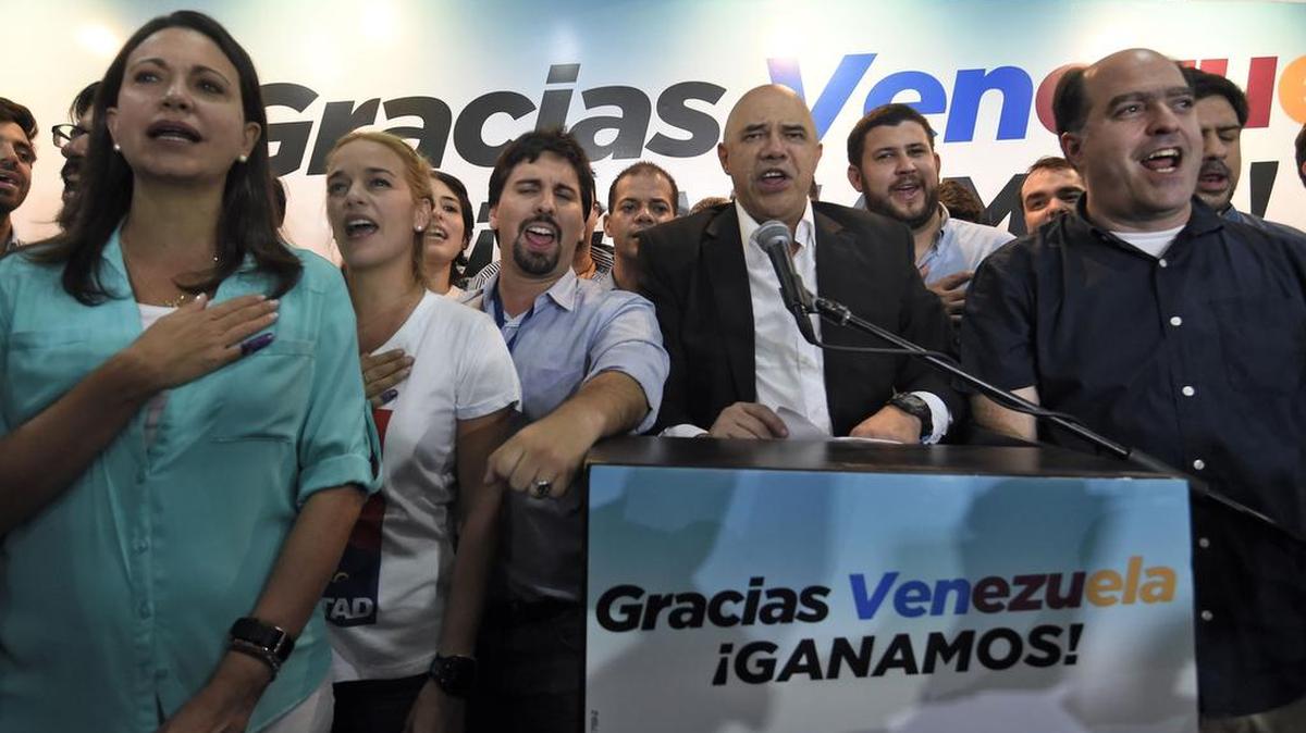 Miembros de la coalición opositora Mesa de Unidad Democrática (MUD) celebran la victoria el lunes 7 de diciembre de 2015, en la ciudad de Caracas (Venezuela). La presidenta del Consejo Nacional Electoral (CNE) de Venezuela, Tibisay Lucena, anunció hoy que la alianza opositora MUD ganó las elecciones legislativas con un total de 99 diputados frente a 46 del chavismo.