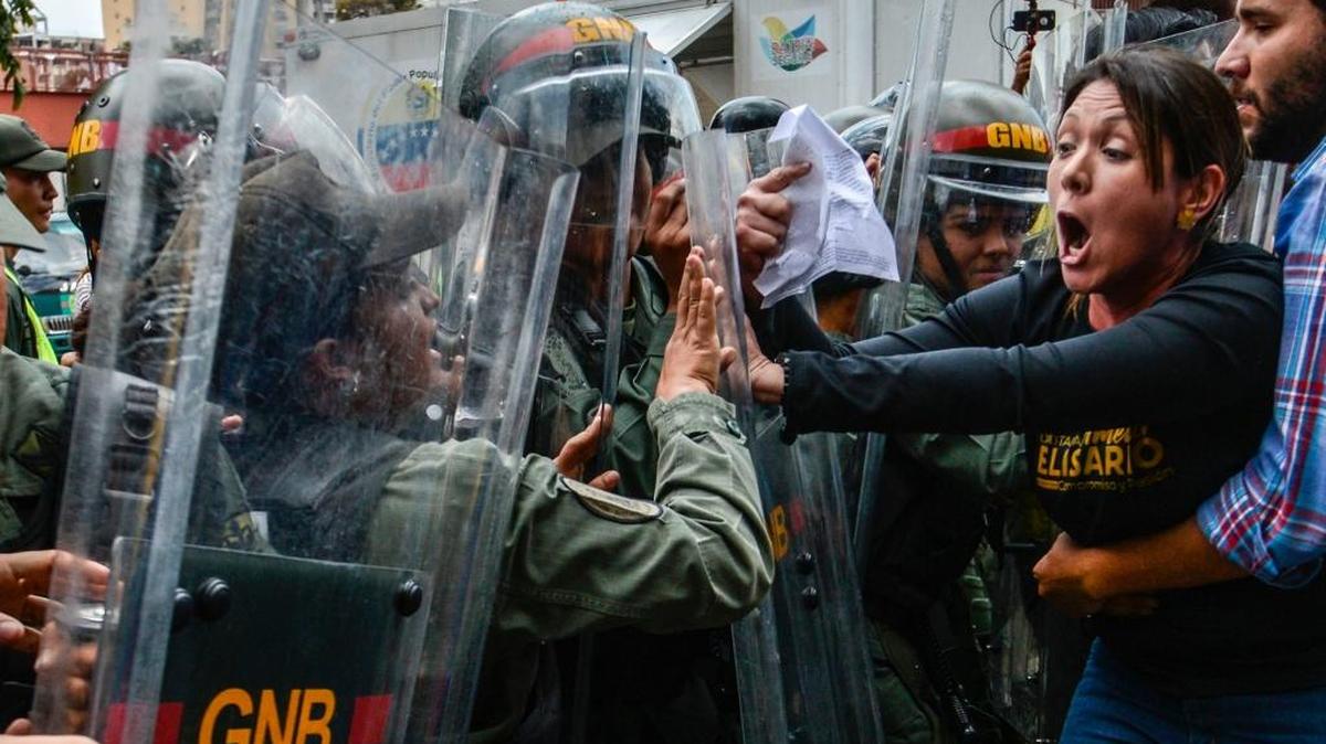 La diputada venezolana Amelia Belisario (2da der.) se enfrenta a la agentes de la Guardia Nacional en una protesta frente al Tribunal Supremo en Caracas, el 30 de marzo.