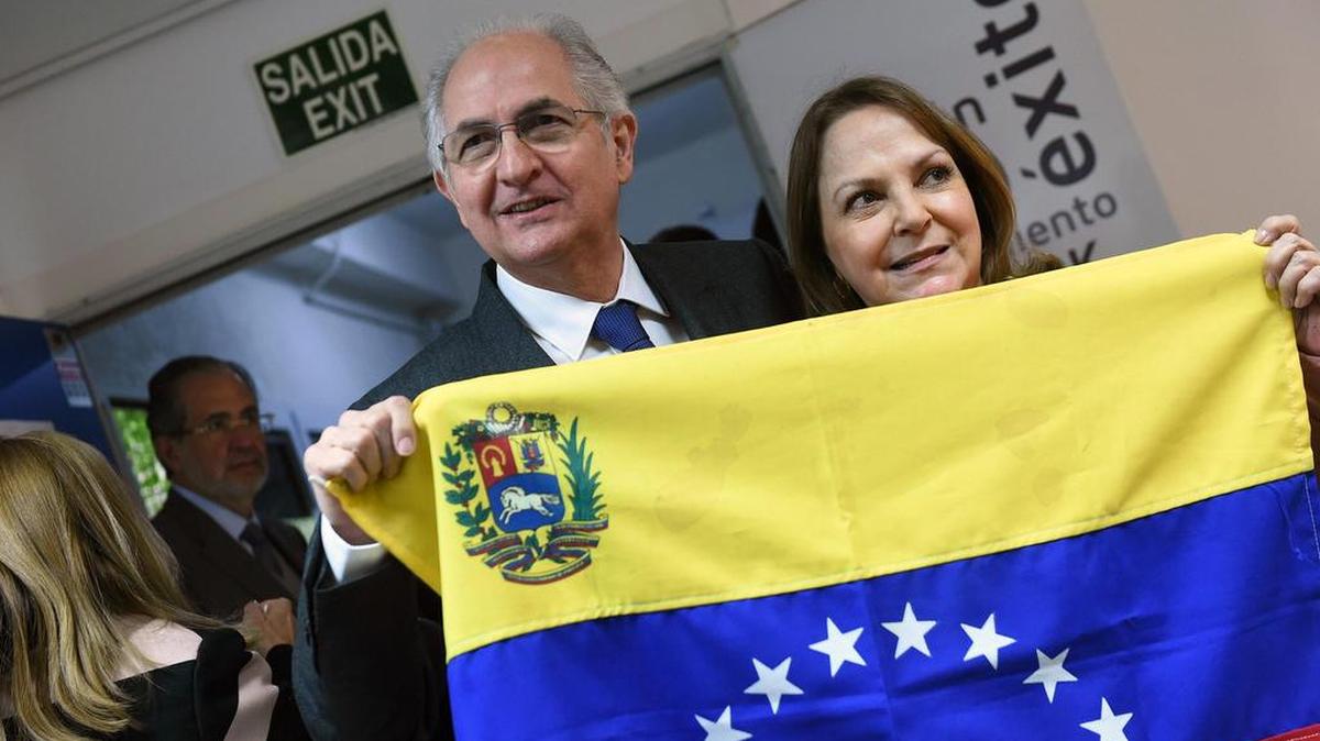 El alcalde metropolitano de Caracas y opositor venezolano, Antonio Ledezma posa junto a su esposa, Mitzy Capriles, con una bandera de Venezuela, antes de la rueda de prensa que ofreció el lunes en Madrid.