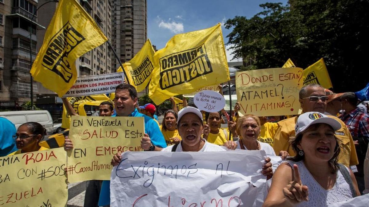 Un grupo de personas grita consignas y ondea banderas de partidos políticos en durante una manifestación en Caracas el viernes.