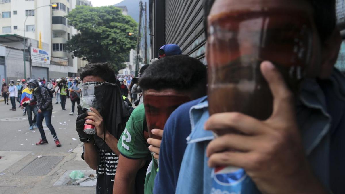 Manifestantes opositores se cubren los rostros con máscaras antigases caseras durante una marcha de protesta en Caracas el 3 de mayo del 2017.