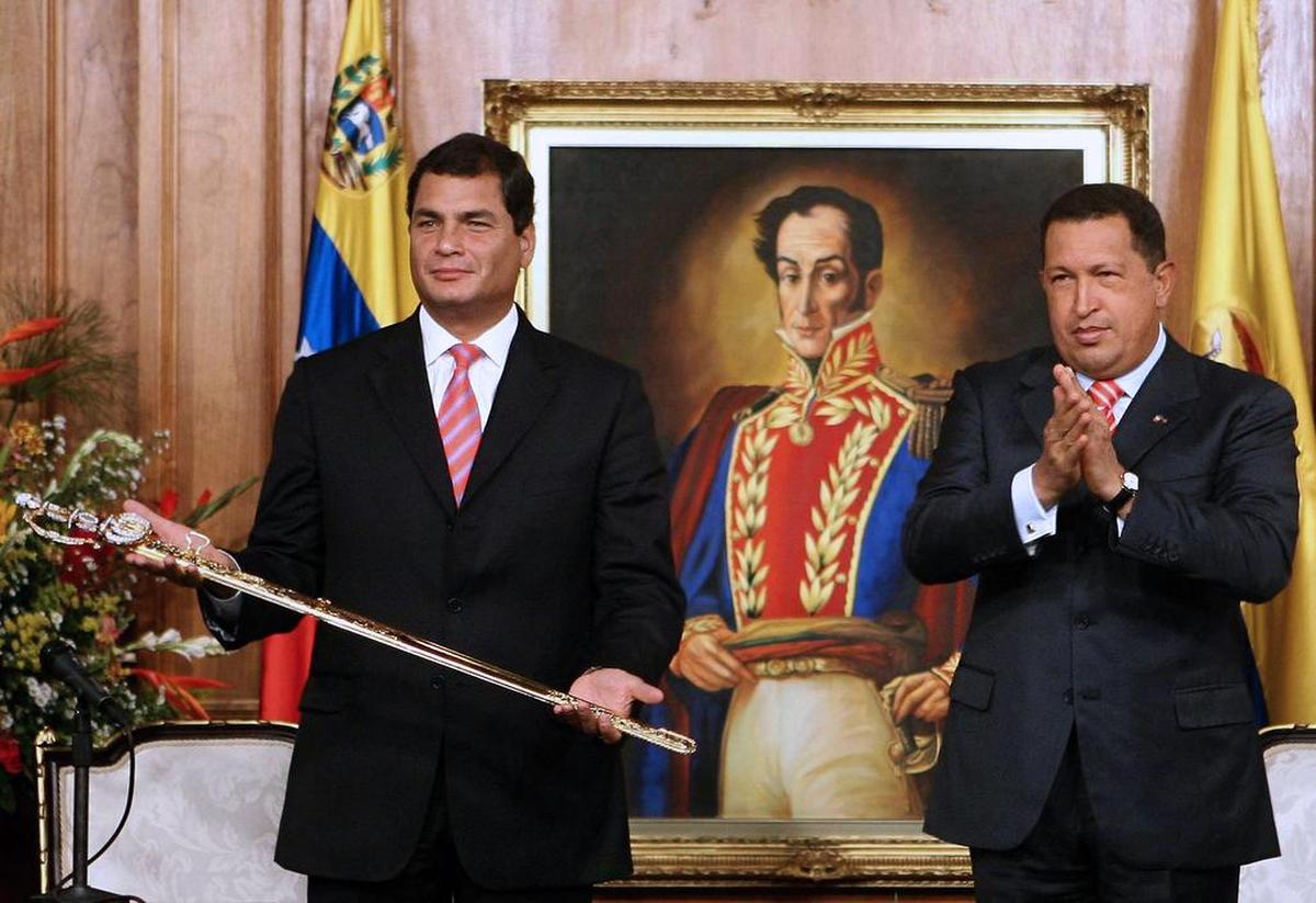El ex presidente venezolano Hugo Chávez (R) aplaude después de dar al entonces presidente electo Rafael Correa una réplica de la espada del libertador Simón Bolívar durante una reunión en el palacio presidencial de Miraflores en Caracas el 21 de diciembre de 2006.