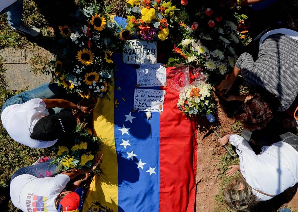Personas depositan flores en la tumba del policía Óscar Pérez en Caracas, el 21 de enero de 2018.