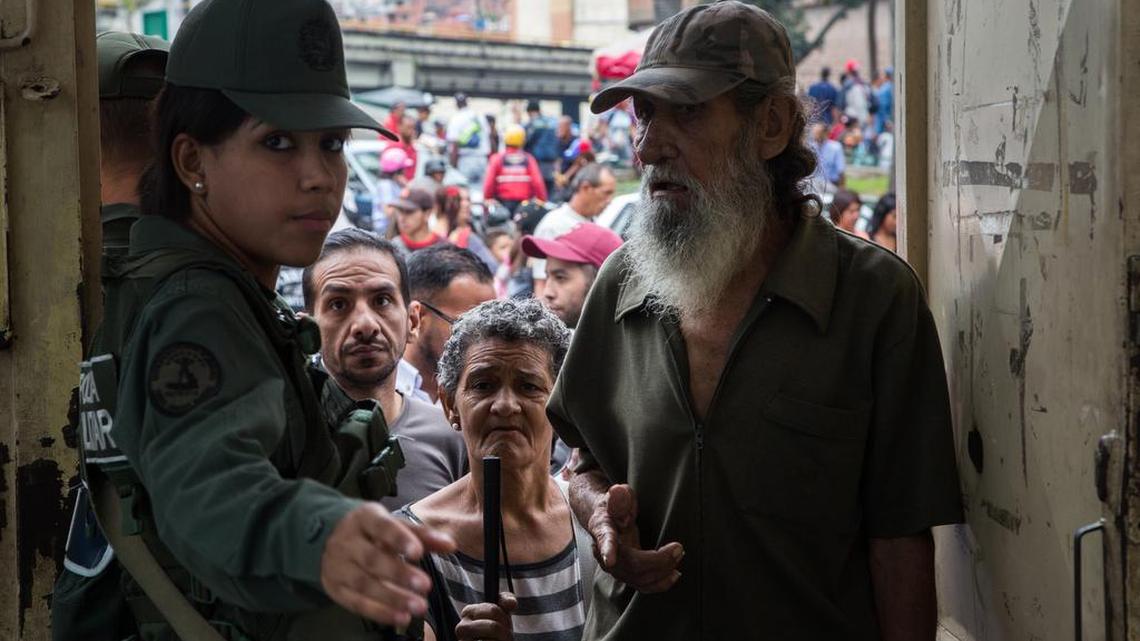 Un miembro del ejército guía a un votante en un centro de votación reubicado antes de las elecciones de gobernadores estatales en Caracas, Venezuela, el 15 de octubre del 2017.