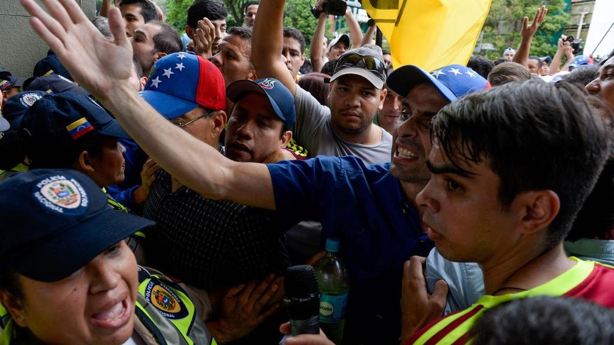 El líder opositor y gobernador del Estado Miranda, Henrique Capriles (centro), habla con miembros de la policía Nacional, durante una protesta en Caracas, Venezuela, este miércoles 11 de mayo.