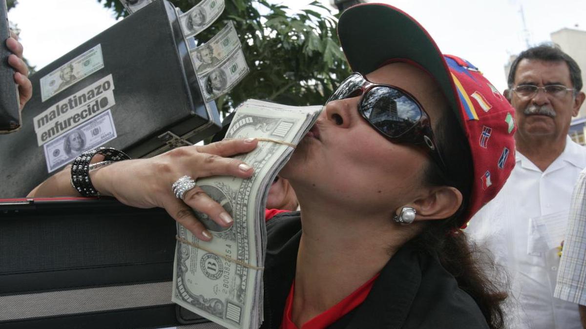 Una mujer besa un fajo de dólares falsos durante una manifestación contra la corrupción en Caracas, en agosto del 2007.