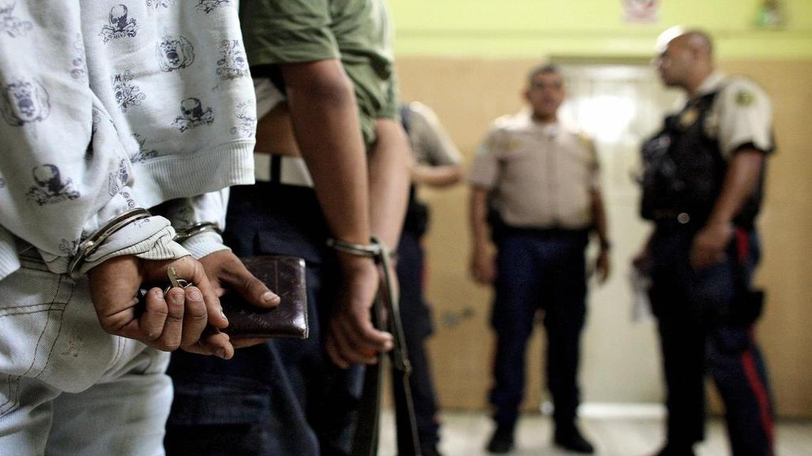 Dos adolescentes venezolanos esperan en una estación de policía tras ser arrestados en Caracas en marzo del 2009.