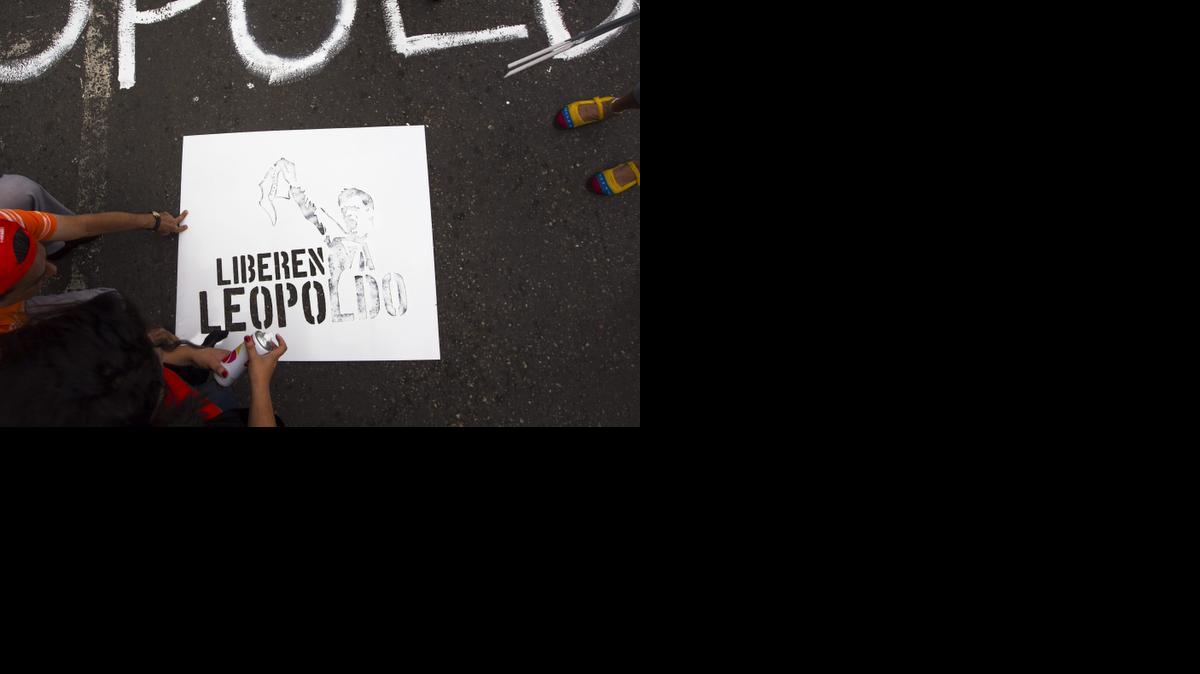 
Dos personas dejan un grafiti en una calle pidiendo la liberación del líder opositor Leopoldo López. Foro de archivo de una concentración frente al Palacio de Justicia en la ciudad de Caracas, Venezuela.
