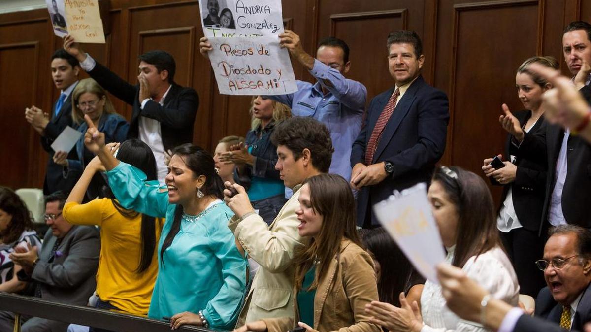 Familiares de presos políticos muestran afiches en el palco de invitados del hemiciclo de sesiones de la Asamblea Nacional para exigir la liberación de los presos políticos.