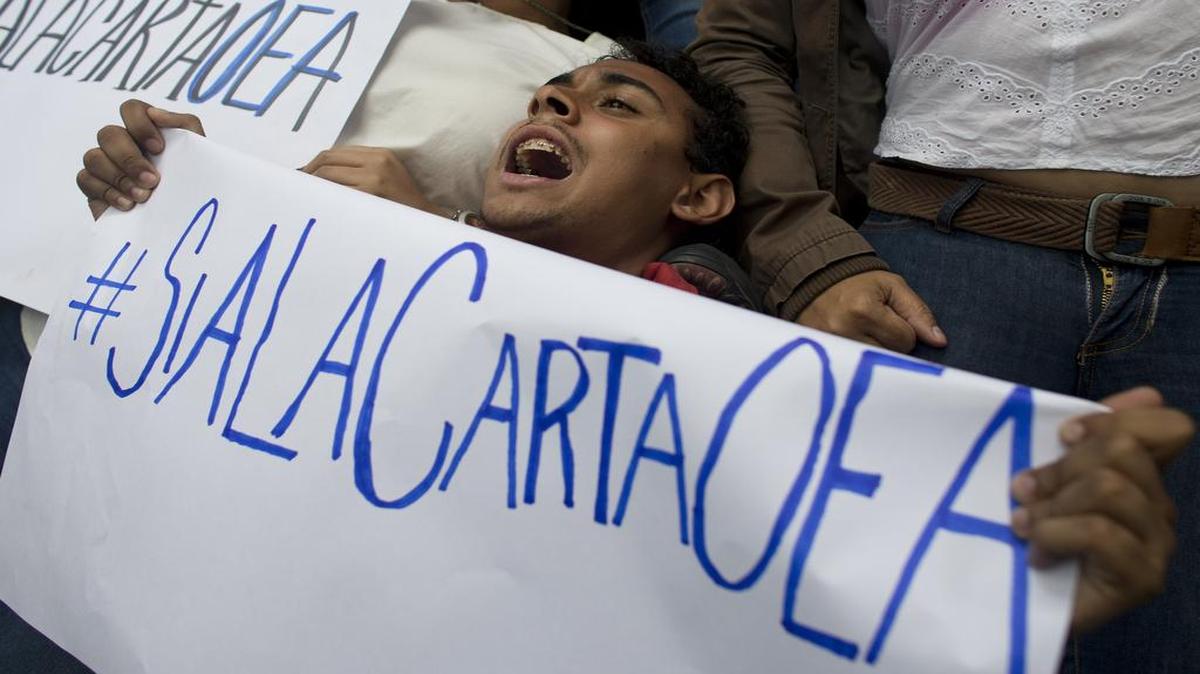 Un simpatizante de la oposición venezolana se manifiesta a favor de la aplicación de la carta democrática frente a las oficinas de la OEA en Caracas el 23 de junio del 2016.