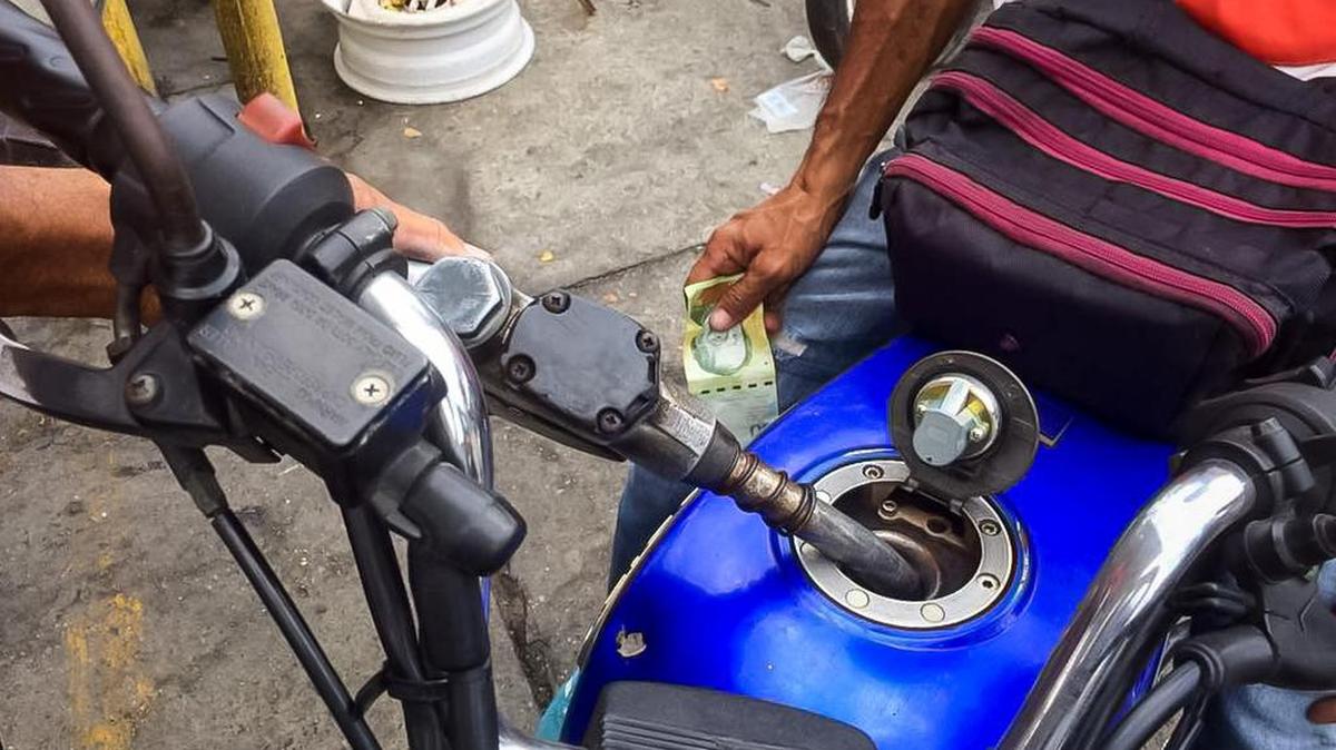 Un hombre pone gasolina a una moto en una estación de Petróleos de Venezuela, donde se evidencia retraso en la venta de combustible, el 20 de diciembre del 2017, en la ciudad de Valera, Venezuela. Petróleos de Venezuela (PDVSA) dijo que la escasez de combustible en varios estados del oeste del país se debe al "bloqueo internacional" en su contra, ofreció disculpas e informó que el servicio se normalizará en "las próximas horas".