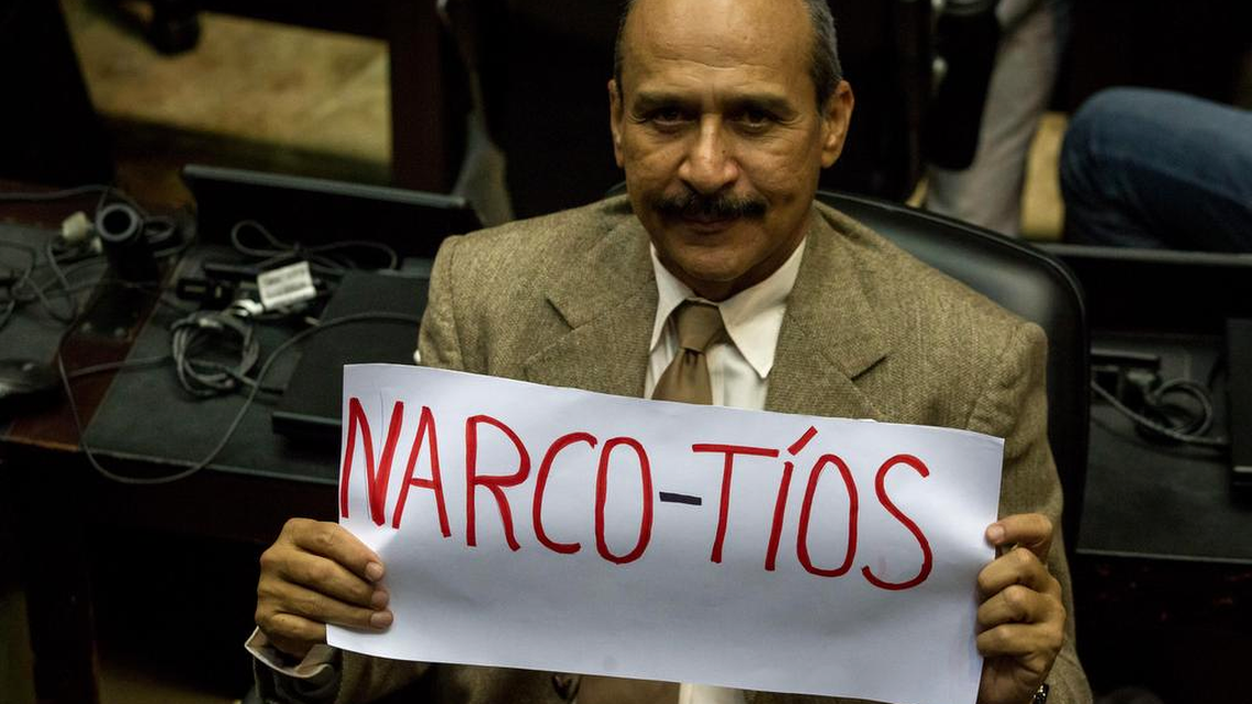 El diputado de la Asamblea Nacional (AN) por la coalición opositora Mesa de Unidad Democrática (MUD) Luis Silva sostiene un cartel que dice "Narco-Tios" el martes 22 de noviembre de 2016, en Caracas (Venezuela). El parlamento venezolano debate sobre la declaración de culpabilidad por delitos de narcotráfico a dos sobrinos directos de la primera dama venezolana Cilia Flores, esposa del presidente Nicolás Maduro.