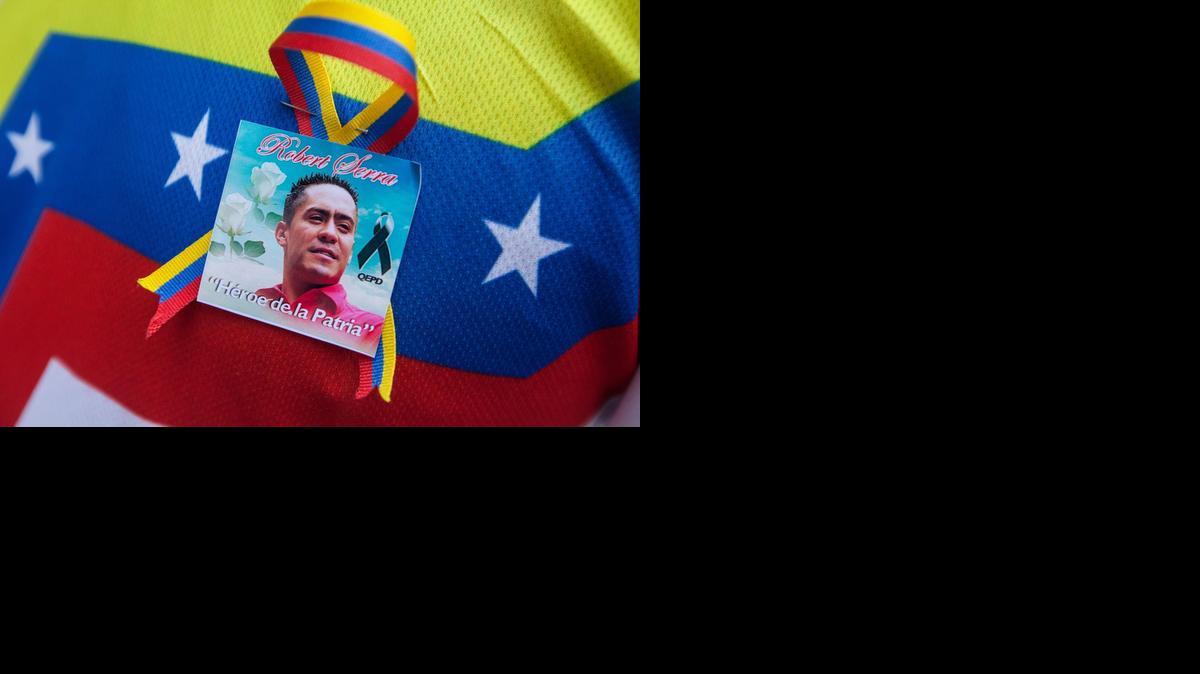 
Una persona usa un adorno con la imagen del diputado asesinado Robert Serra, el viernes en Caracas. El gobierno de Venezuela decretó tres días de duelo nacional por la muerte del legislador chavista. 
