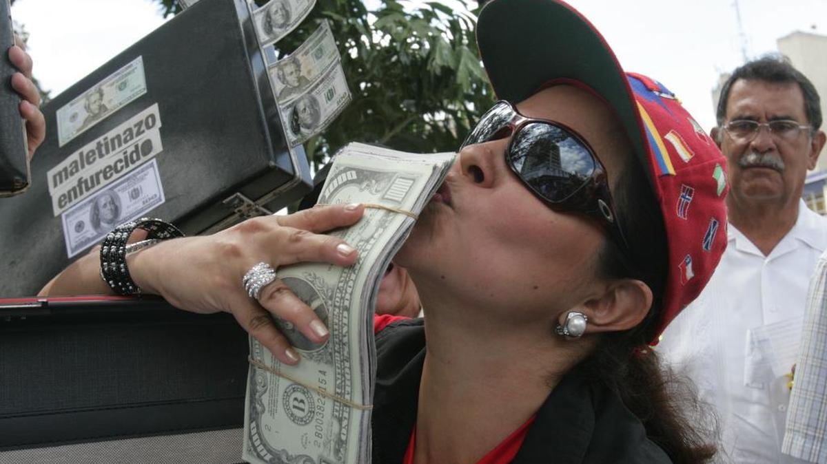 Una mujer besa un fajo de billetes falsos de dólar durante una manifestación en Caracas contra la corrupción en la estatal Petróleos de Venezuela en el 2007.