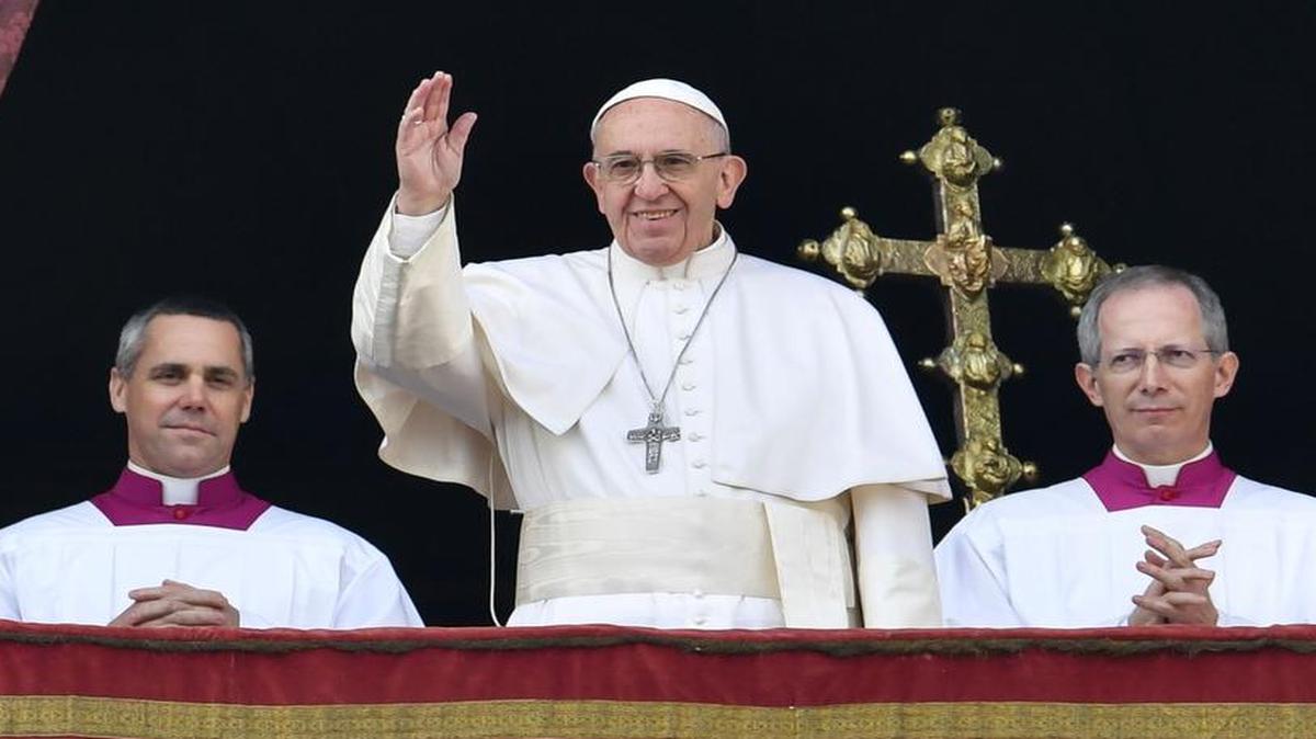 El papa Francisco, centro, saluda desde el balcón de la Basilica de San Pedro, durante su mensaje navideño al mundo, el 25 de diciembre del 2016.
