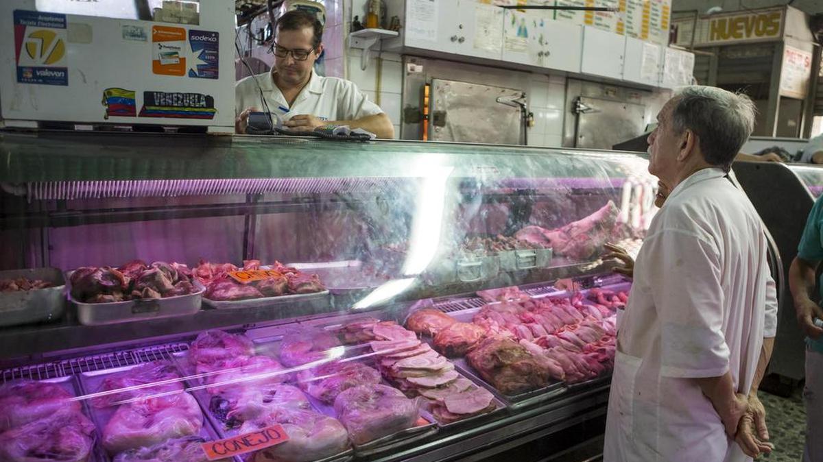 Un hombre pregunta por los precios de la carne en un mercado popular el 2 de noviembre del 2017, en Caracas (Venezuela).