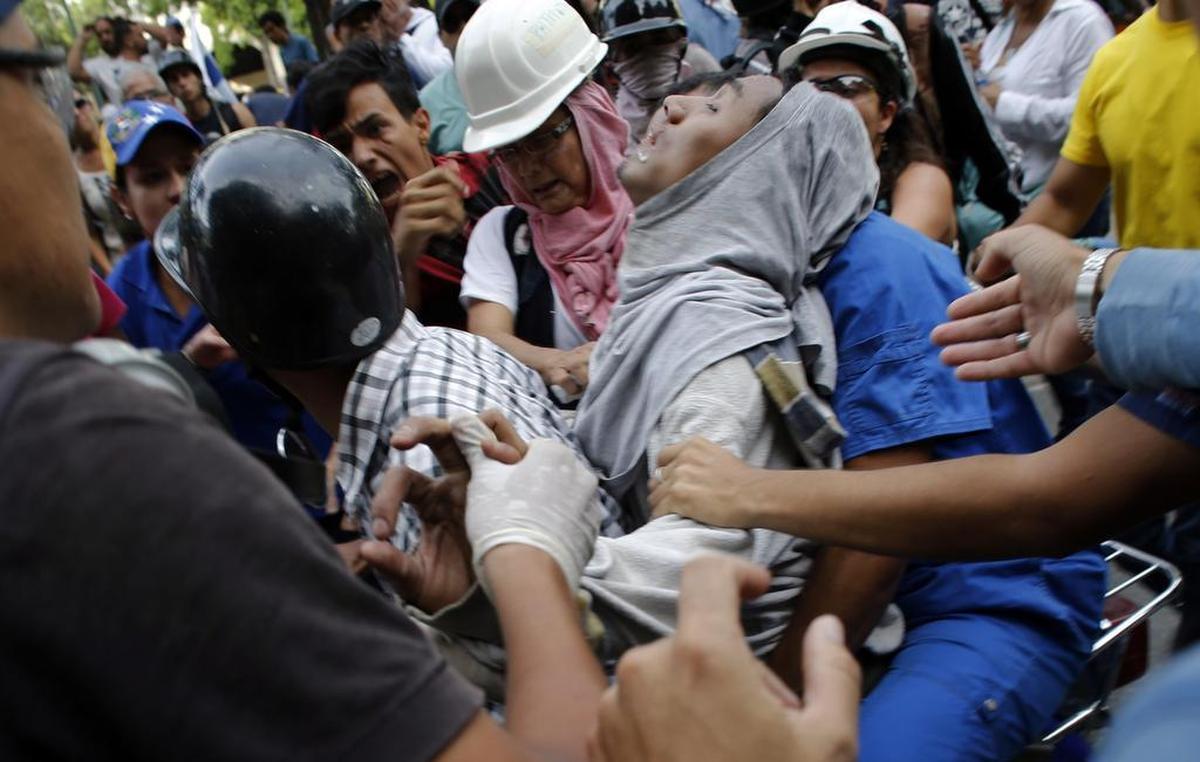 Un manifestante herido durante enfrentamientos con las fuerzas de seguridad es transportado en una motocicleta en Caracas, Venezuela, el miércoles 31 de mayo de 2017.