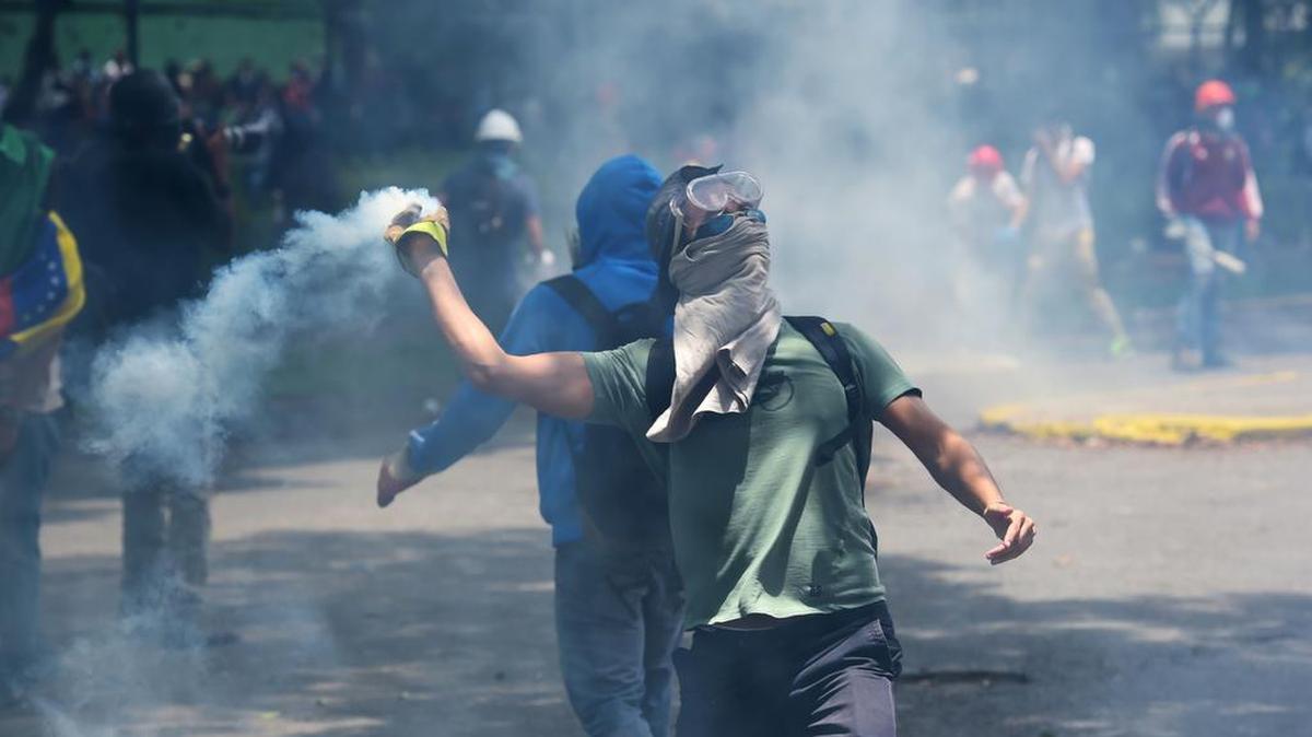 Un estudiante de la Universidad Central de Venezuela devuelve una bomba lacrimógena durante una protesta contra el gobierno de Nicolás Maduro, el jueves 4 de mayo de 2017, en Caracas.