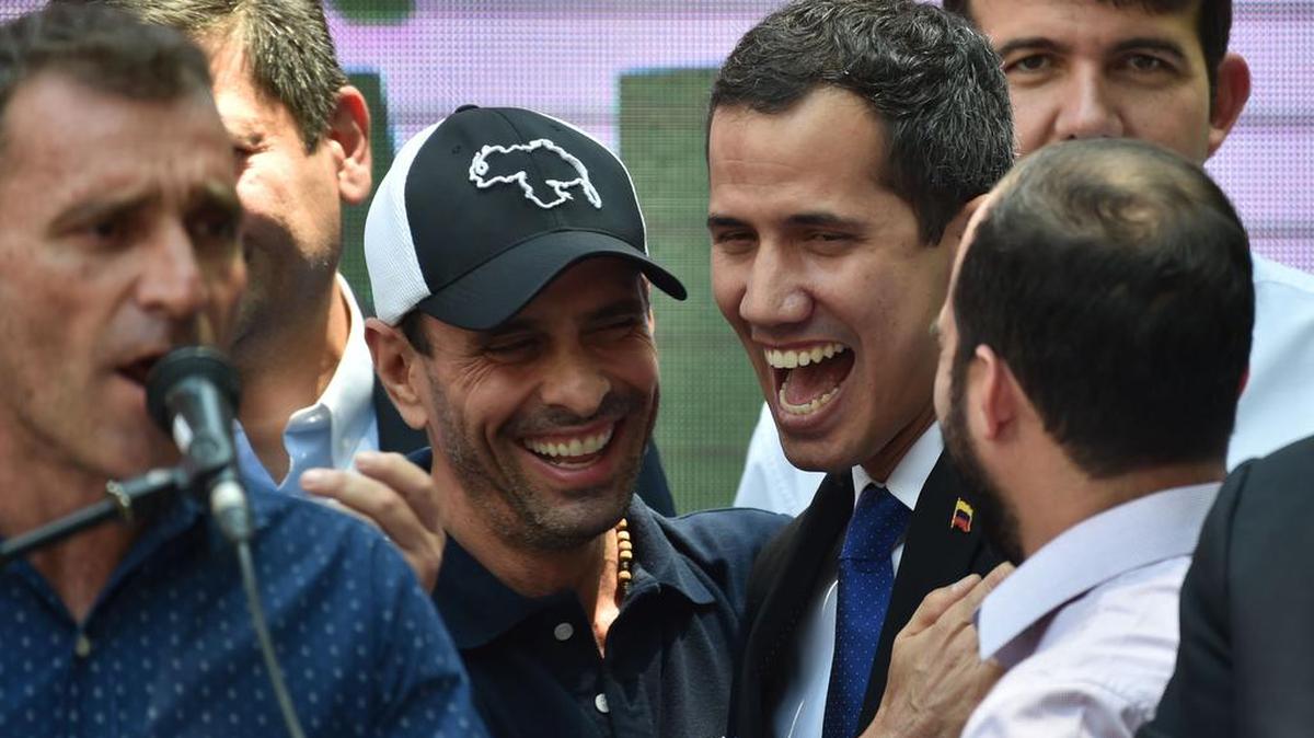 El líder opositor Henrique Capriles (cen.-izq.) participa con el presidente interino venezolano Juan Guaidó (cen.-der.) en un mitin en Caracas, el 27 de marzo del 2019.