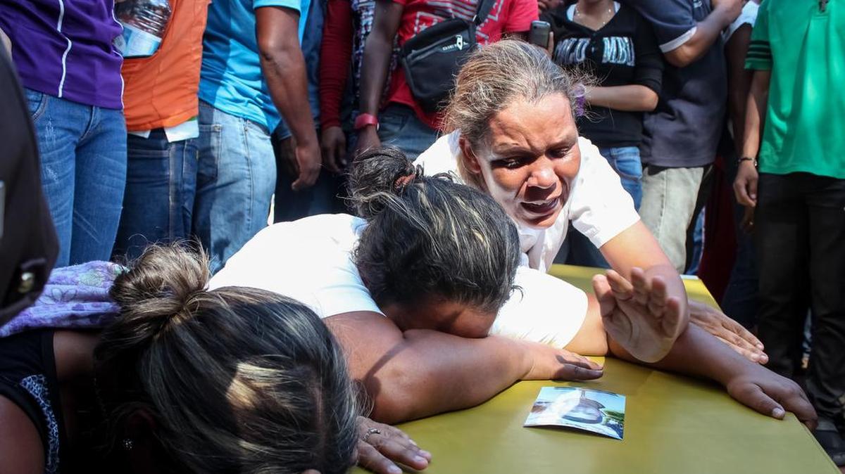 Familiares de los mineros desaparecidos lloran sobre sus ataudes el martes 16 de marzo del 2016, en la localidad de Tumeremo en el estado Bolívar (Venezuela).