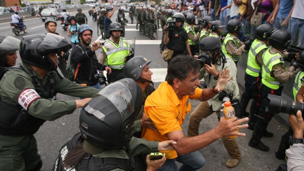 Efectivos de la Guardia Nacional forcejean con un manifestante, después de reprimir con gases lacrimógenos a cientos de civiles durante una protesta en Caracas.