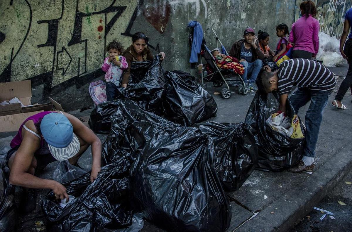 Varias familias buscan y consumen los restos de comida que consiguen en las bolsas de basura, el 10 de febrero, en Caracas, Venezuela. Según un reporte reciente de la ONU y la Organización Panamericana de la Salud, al menos 1.3 millones de venezolanos tienen dificultades para conseguir comida desde que la aguda crisis económica se acrecentó hace tres años.