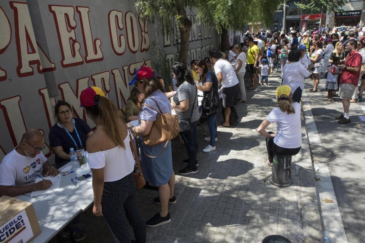 La comunidad venezolana de Barcelona vota en la calle la votación popular contra Nicolás Maduro ante la negativa del Ayuntamiento a que se realizase en un centro cívico ante la falta de permisos.