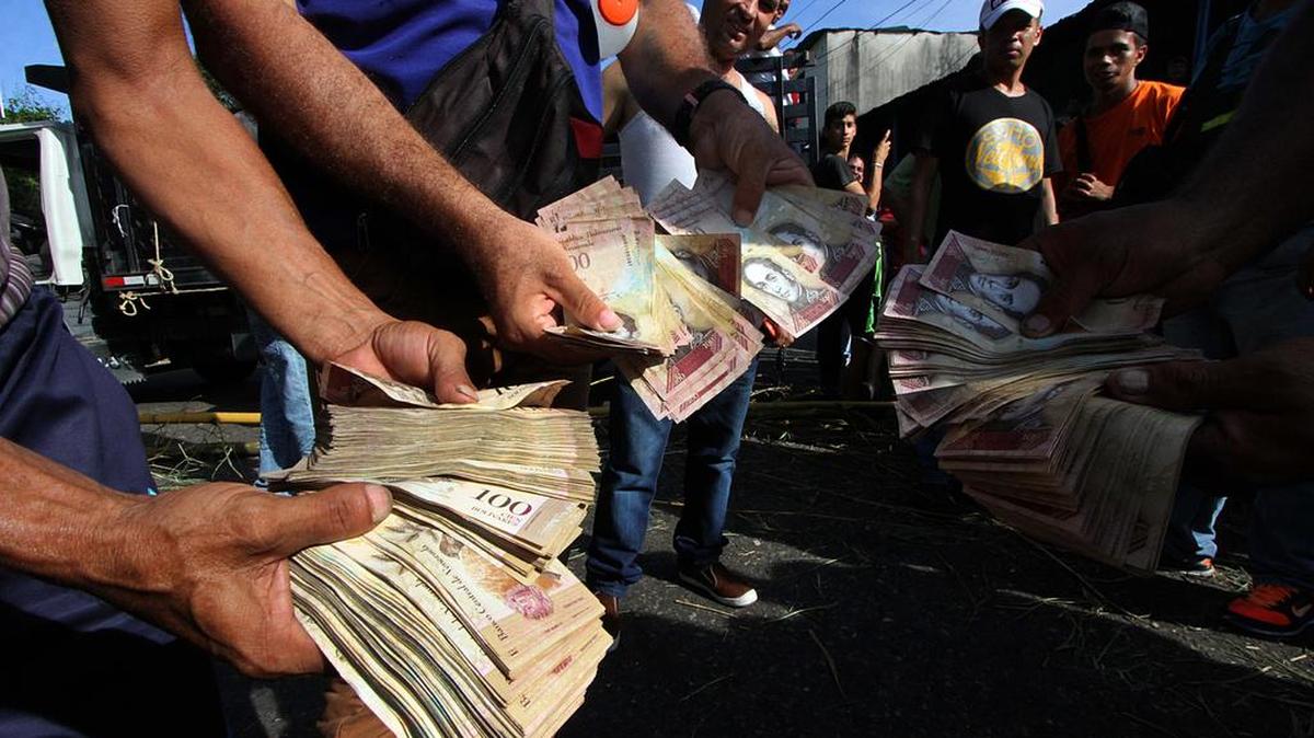 Personas protestan por la falta de dinero en efectivo, ya que los nuevos billetes no han aparecido en San Cristóbal, en el estado Táchira de Venzuela, el 16 de diciembre de 2016. Los venezolanos se alinearon para depositar billetes de 100 unidades antes de que perdieran su valor, pero los billetes de reemplazo aún no habían llegado, aumentando el caos en efectivo en el país con la inflación más alta del mundo.