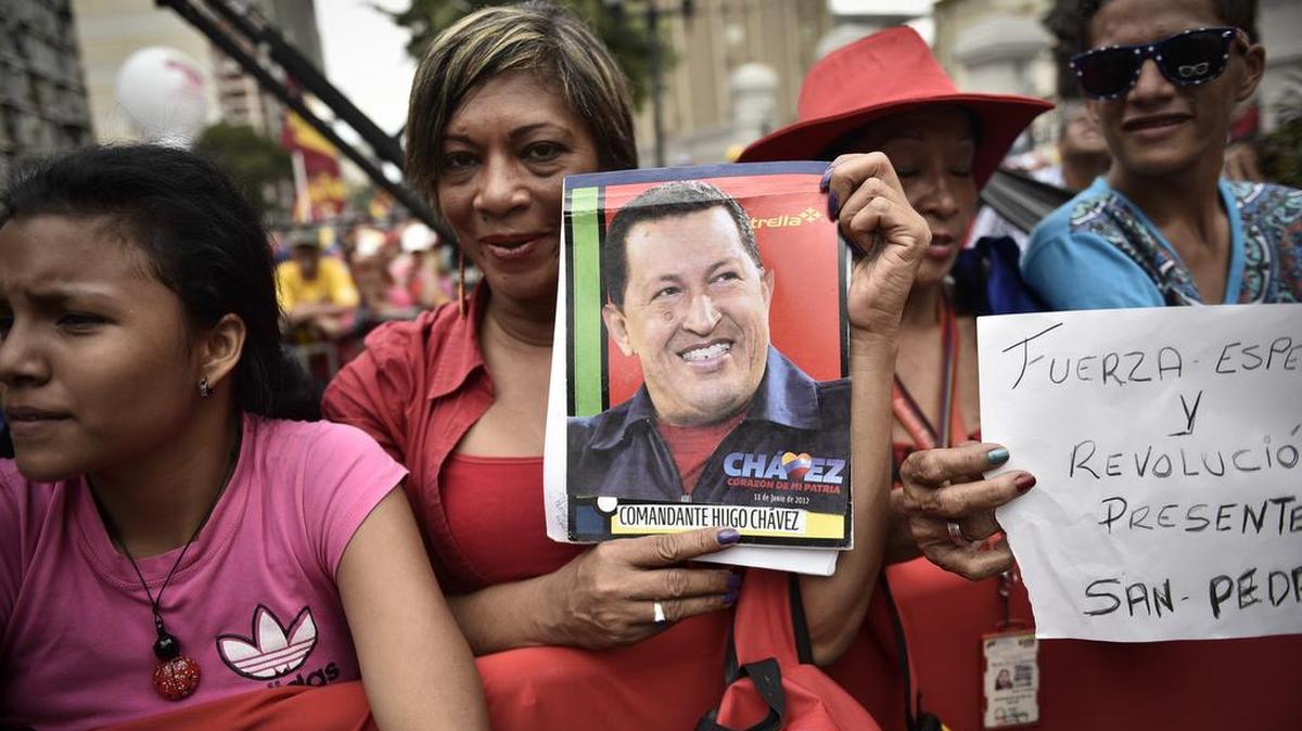 Simpatizantes del presidente venezolano Nicolás Maduro sostienen una imagen del ex presidente fallecido Hugo Chávez, el viernes en Caracas.