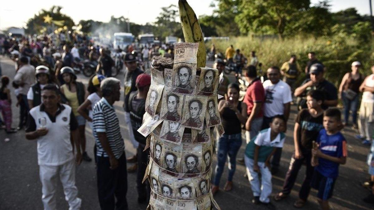 Los manifestantes se reúnen alrededor de un tótem improvisado hecho de billetes de 100 bolívares expirados durante una protesta en El Pinal, Táchira, Venezuela, el viernes 16 de diciembre de 2016.