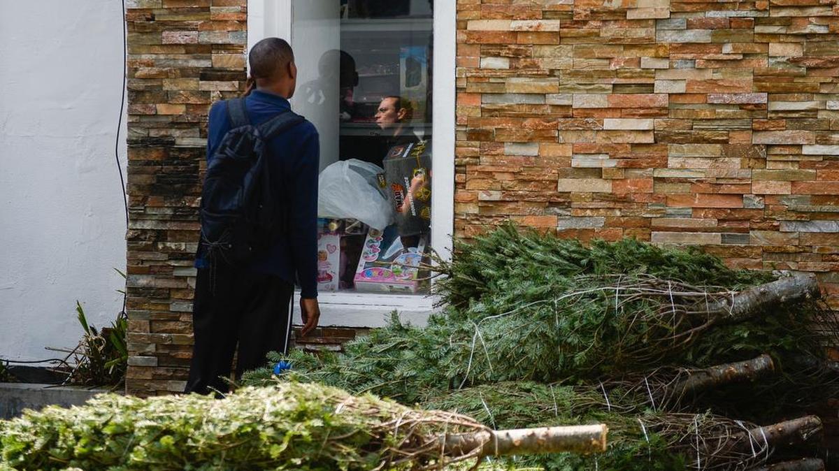Un hombre mira la ventana de una tienda de juguetes con ofertas de Navidad, en Caracas el 22 de diciembre de 2016.