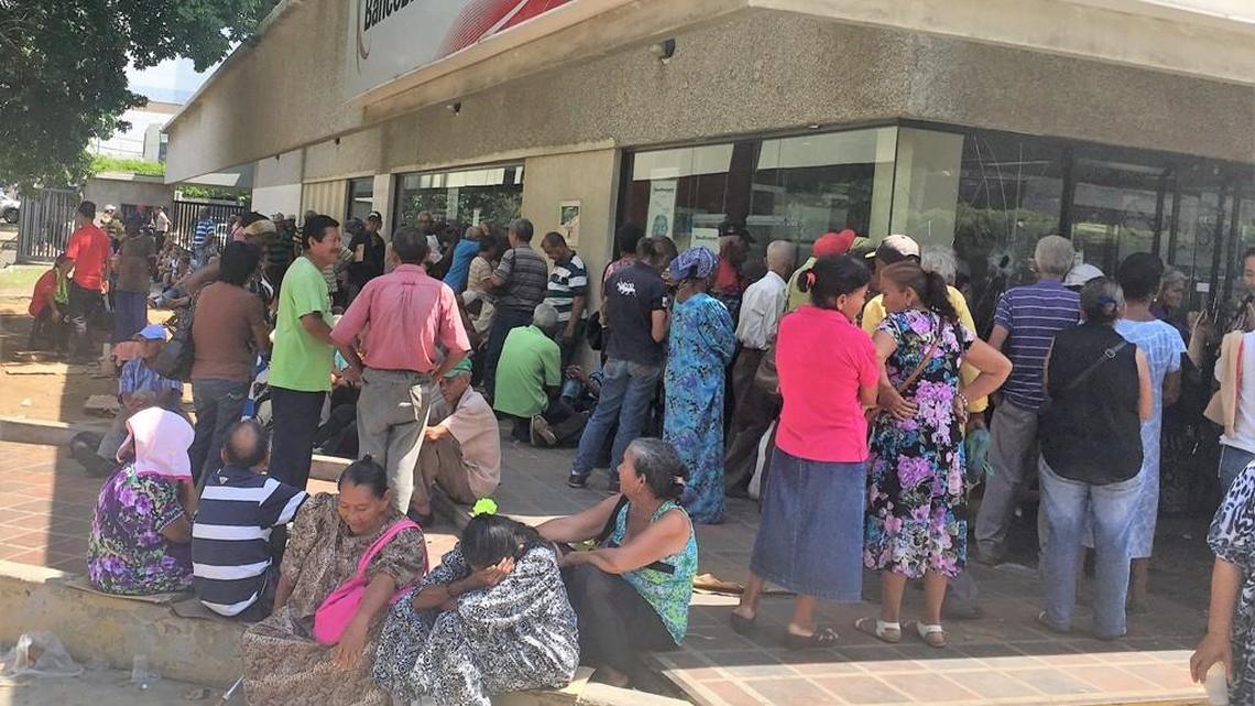 Venezolanos de la tercera edad hacen fila durante horas todos los meses en los bancospara cobrar la pensión mensual del gobierno.