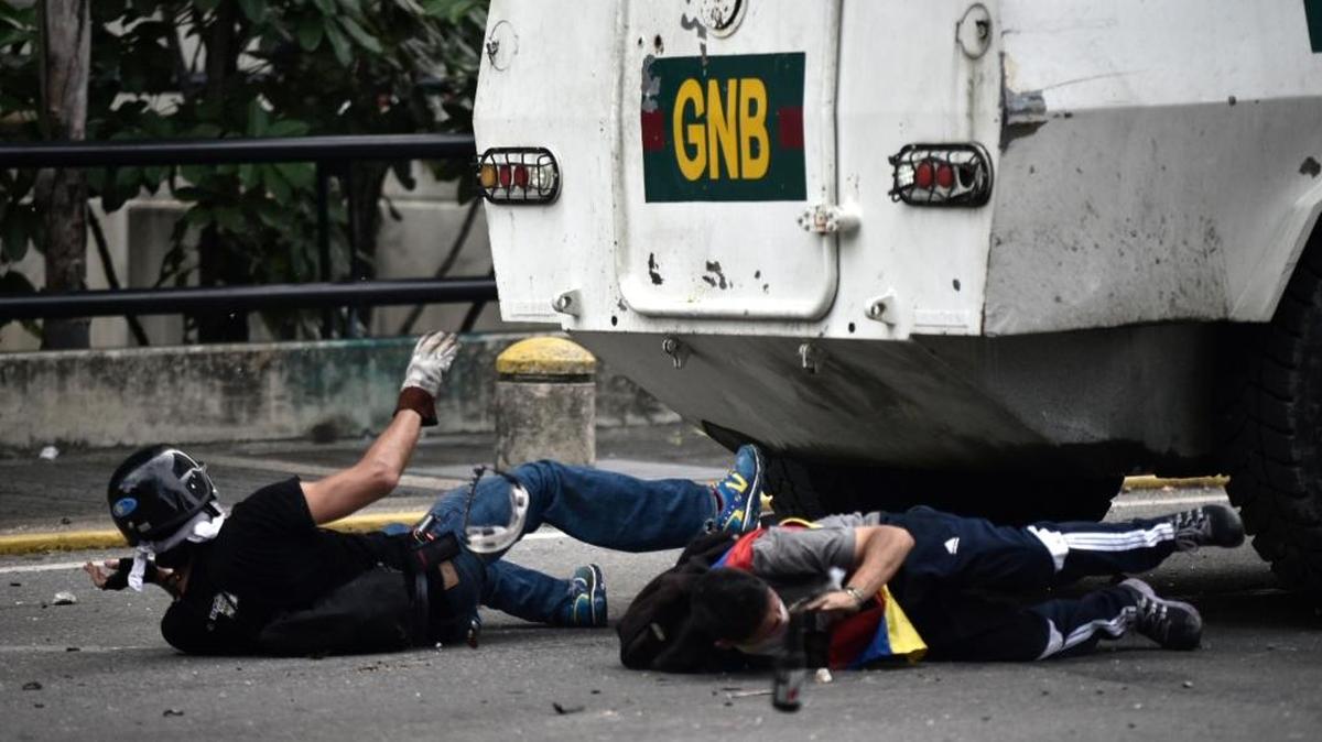 Manifestantes son arrollados por un vehículo de la Guardia Nacional durante las protestas en Caracas, el 3 de mayo.
