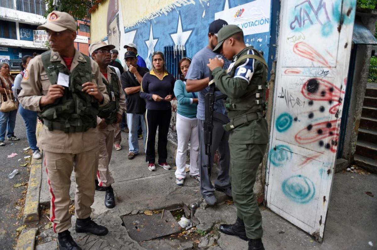 Varias personas asisten a un centro de votación el 15 de octubre de 2017, en Caracas (Venezuela).