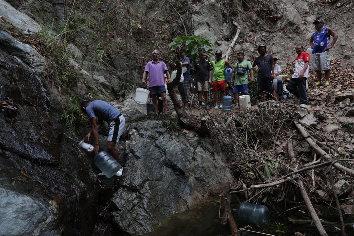 Grupos de personas recogen agua este lunes, en las caídas de agua del Cerro el Ávila, en Caracas (Venezuela).