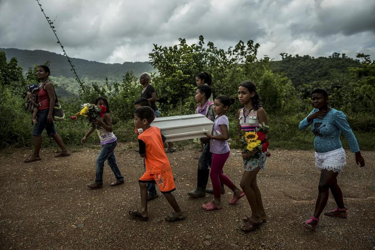 Niños cargan el ataúd de Kleiver Enrique Hernández de 3 meses de edad, un viaje de más de dos horas y media, sobre colinas y arroyos de poca profundidad, hasta el cementerio desde su casa en Urdaneta, Venezuela, el 17 de agosto de 2017.