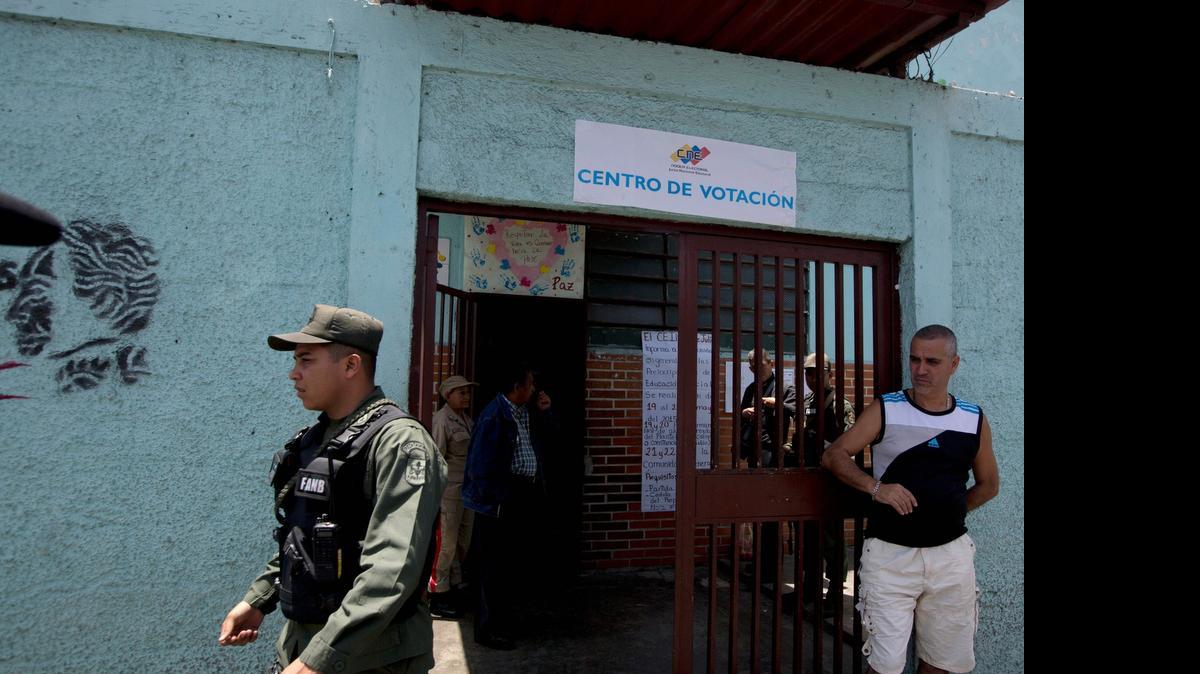 
Un integrante de la Guardia Nacional Boliviariana custodia el domingo un centro de votación en Caracas. La MUD realizó elecciones primarias para elegir los candidatos a los comicios parlamentarios de este año.
