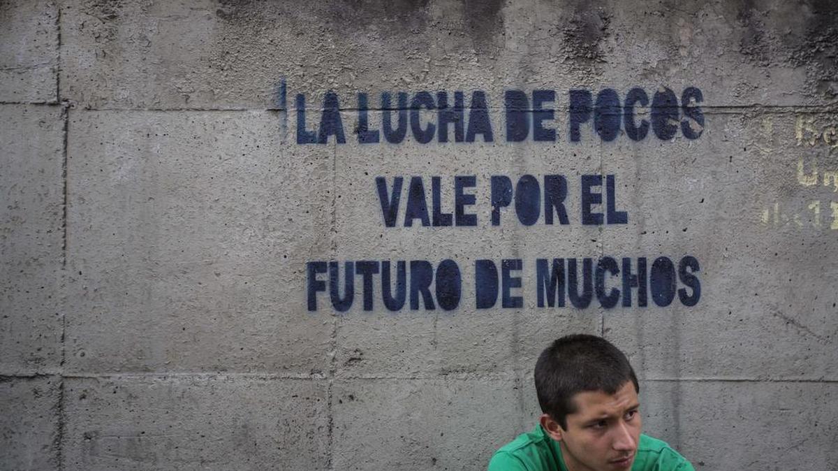 Un joven permanece debajo de un grafiti durante una protesta antigubernamental el lunes 24 de julio de 2017, en Caracas (Venezuela).