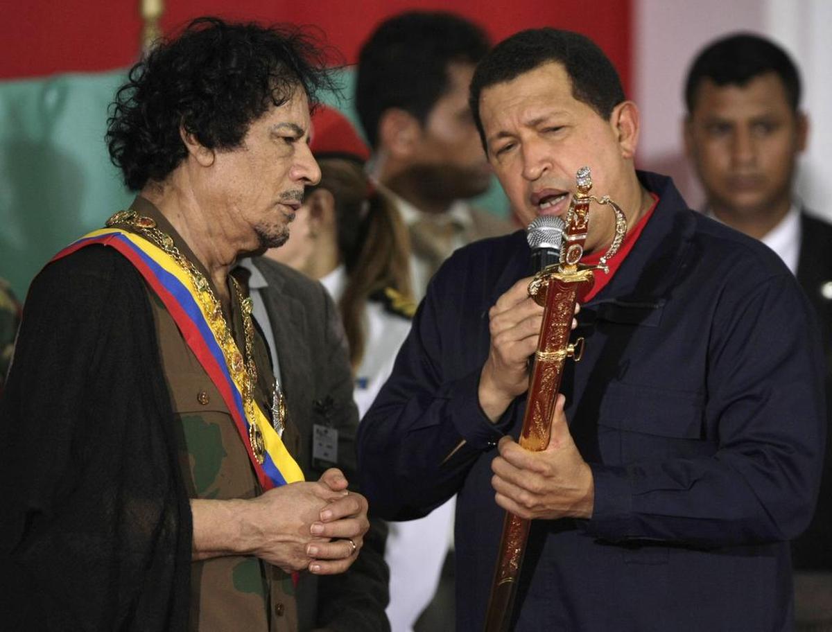 En la foto de este archivo del 28 de septiembre de 2009, el ex presidente de Venezuela, Hugo Chávez, muestra al ex presidente de Libia, Moammar Gadhafi, una réplica de la espada de Simón Bolívar, heredero de la independencia venezolana, después de regalársela a Gadhafi en Porlamar, Venezuela.