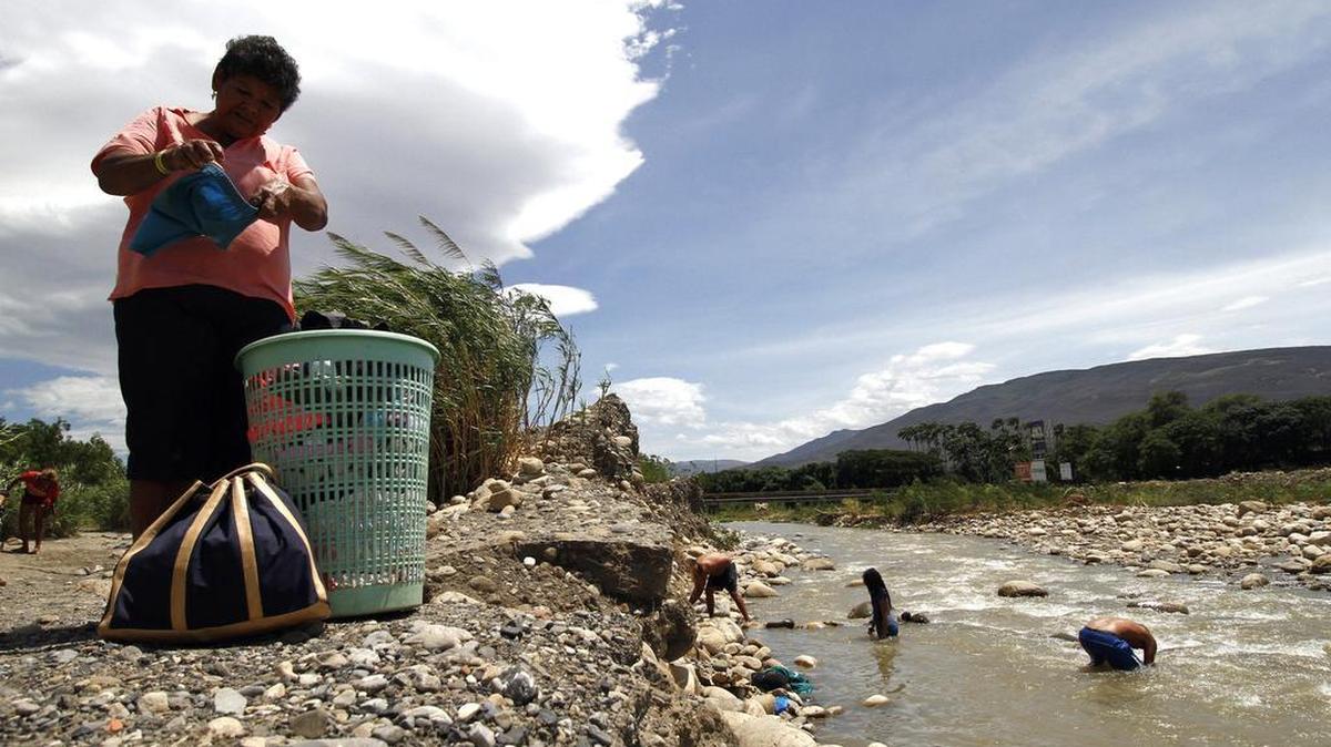 
Una familia colombiana que cruzó desde Venezuela hacia Colombia lava su ropa en el río Tachira hoy, domingo 30 de agosto de 2015, en Cúcuta (Colombia). La Procuraduría de Colombia dijo que investiga los presuntos abusos a colombianas por parte de la Guardia venezolana al cruzar la frontera entre Venezuela y Colombia, que desde hace 11 días está cerrada indefinidamente por orden de las autoridades venezolanas, informaron hoy medios locales. La procuradora delegada para la defensa de los derechos de la Infancia, Adolescencia y Familia, Ilva Myriam Hoyos, afirmó "En las declaraciones que hemos recibido por parte de las personas que están en los albergues nos han manifestado que en el tránsito de la frontera y por la trocha guardias venezolanos han abusado de mujeres", dijo Hoyos al diario El Tiempo. 
