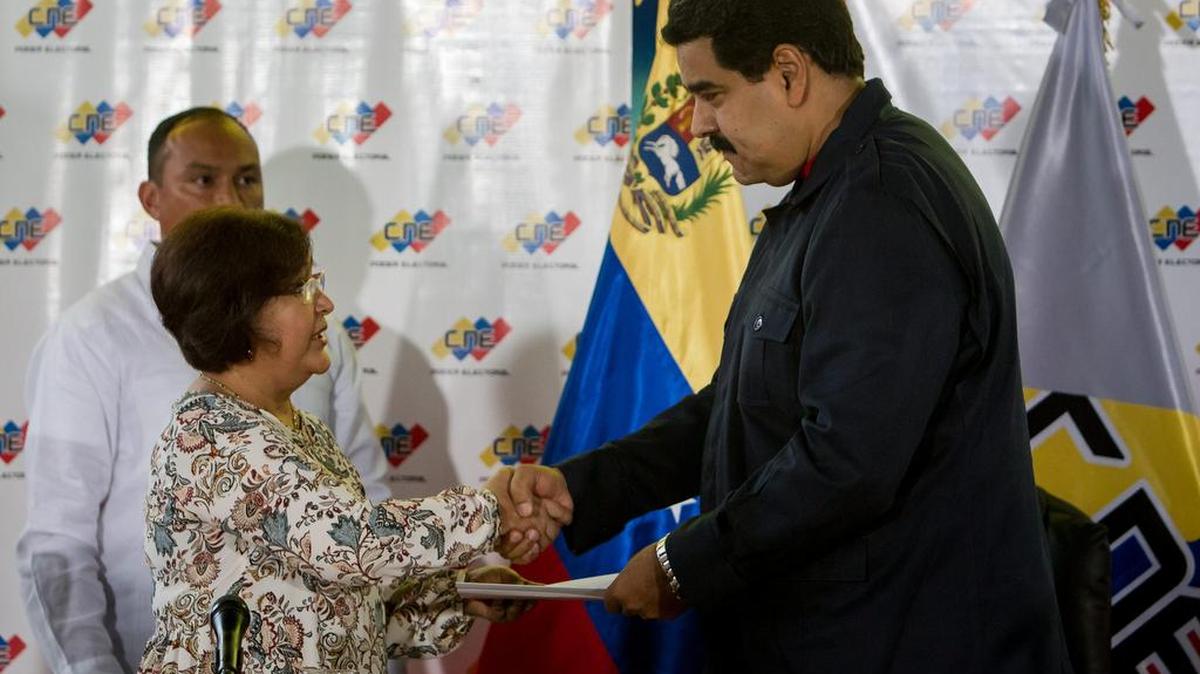 El presidente venezolano, Nicolás Maduro, estrecha la mano de la presidenta del Consejo Nacional Electoral, Tibisay Lucena (i), el lunes 26 de octubre de 2015, en Caracas (Venezuela).