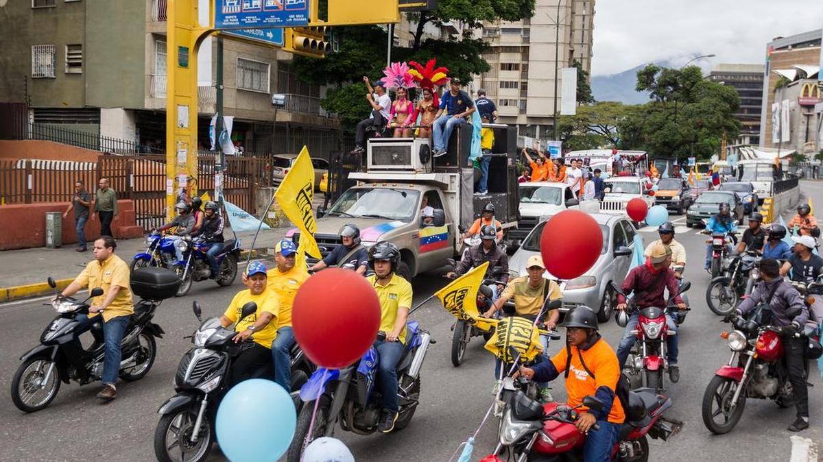 Decenas de personas participan en una caravana organizada por la Mesa de Unidad Democrática (MUD) este sábado 14 de noviembre de 2015, en un acto de campaña para las elecciones a diputados de la Asamblea Nacional en la ciudad de Caracas (Venezuela). La campaña electoral en Venezuela celebra su segunda jornada con actividades de calle y con discursos aderezados con la crisis económica, social y política, que para la oposición es responsabilidad del Gobierno y para el oficialismo es culpa de una "guerra" promovida por EEUU.