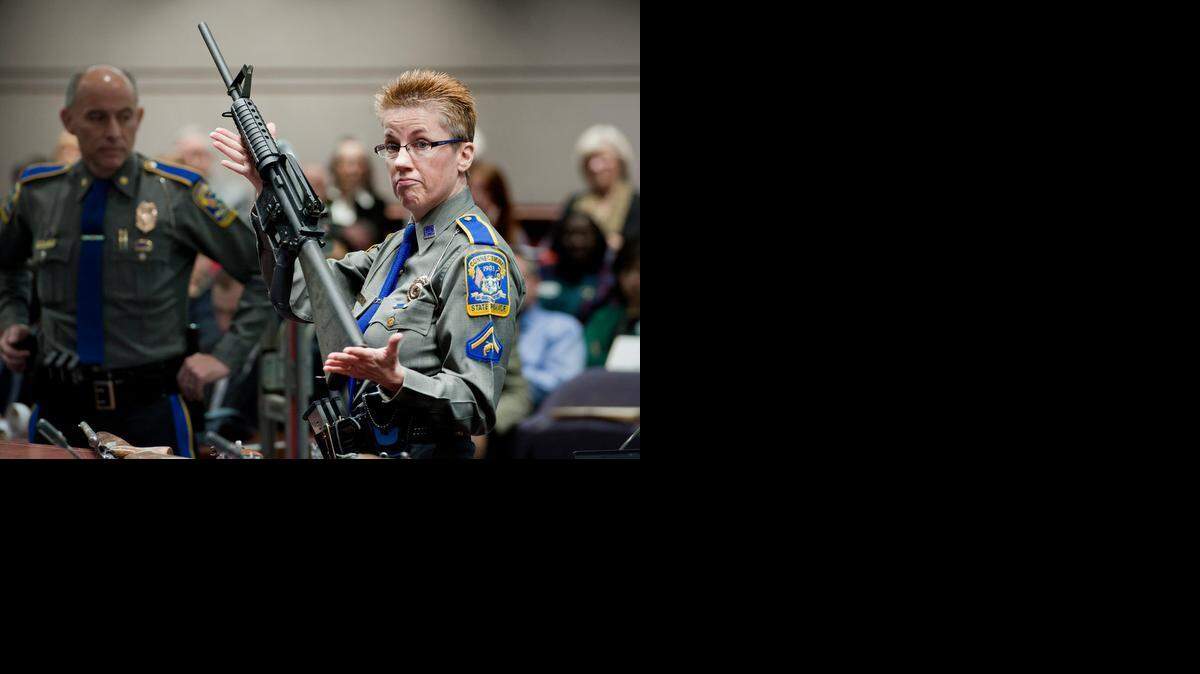 
Una oficial de policía enseña en Corte en enero del 2013 un arma AR-15 como la que usó Adam Lanza para matar a 26 personas en la escuela Sandy Hook, en Connecticut, masacre sucedida en diciembre del 2012. 
