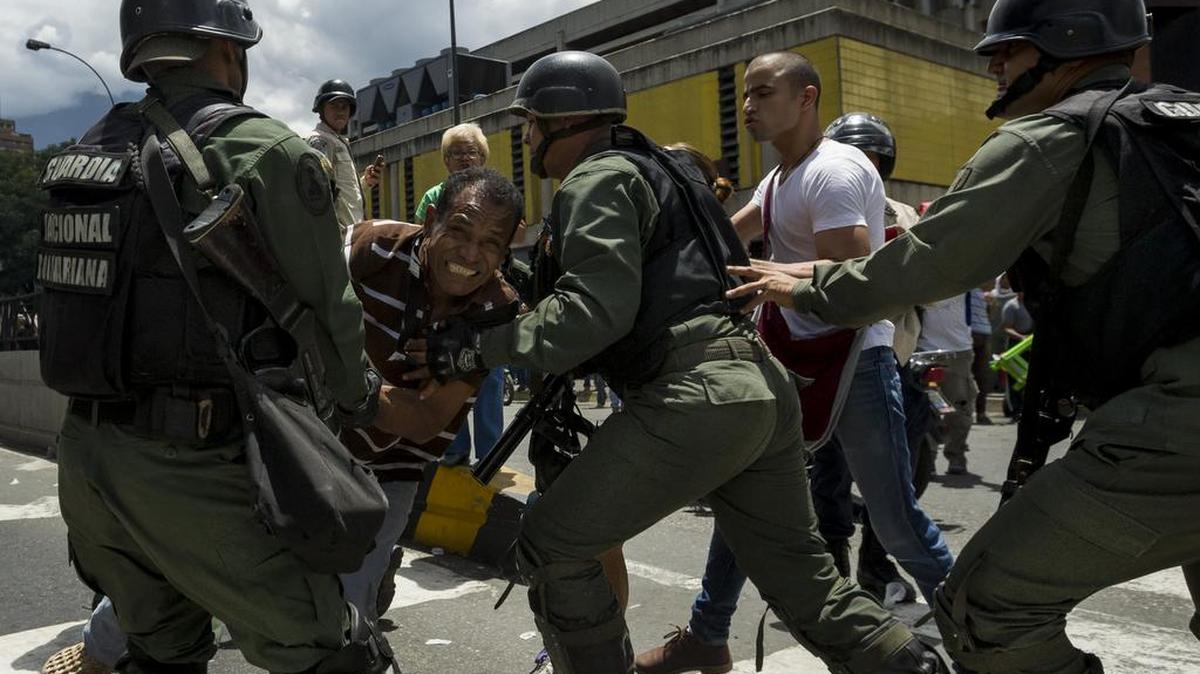 Miembros de la Guardia Nacional Bolivariana y la Policía Nacional Bolivariana detienen a un manifestante en las inmediaciones del sector Petare el miércoles 8 de junio del 2016, en la ciudad de Caracas (Venezuela).