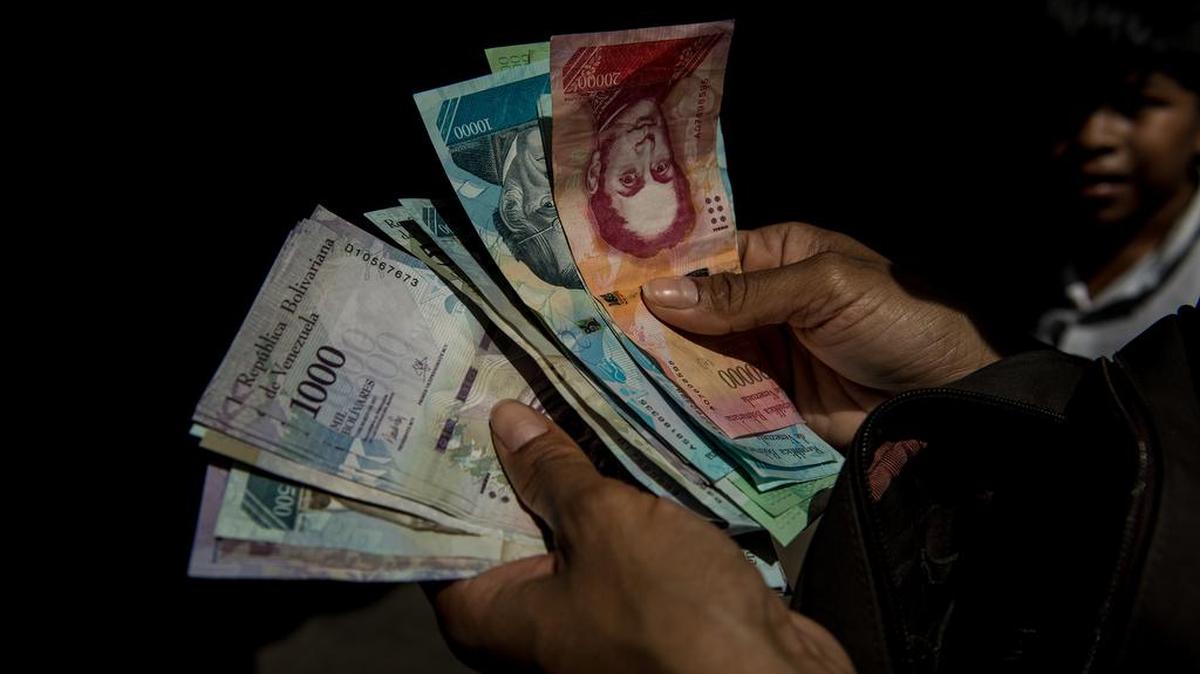 Un cliente cuenta su dinero en un mercado al aire libre de Caracas en noviembre del 2017.