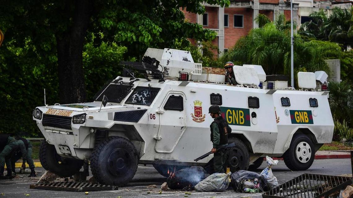 Un vehículo de la Guardia Nacional atraviesa una barricada levantada por manifestantes opositores el 6 de agosto en Valencia, Venezuela.