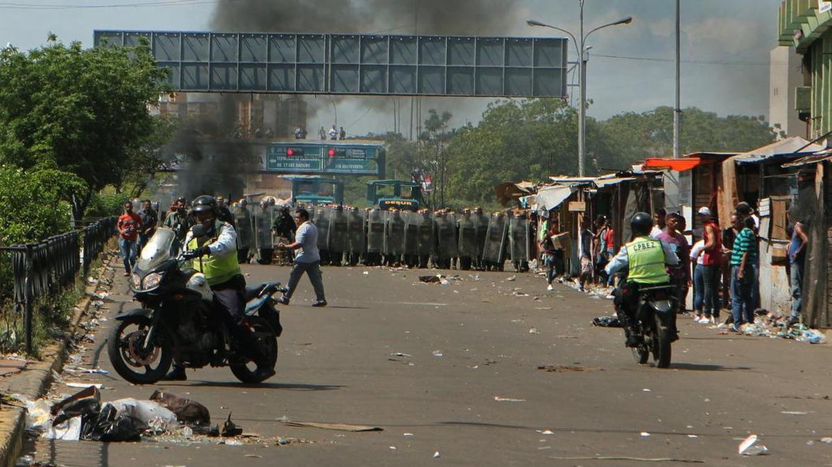 Un grupo de personas protestan en el centro y las inmediaciones del Banco Centra de Venezuela el sábado 17 de diciembre del 2016, en la ciudad de Maracaibo (Venezuela). Decenas de venezolanos protestaron en varios estados del interior del país por fallas en el suministro de dinero en efectivo.