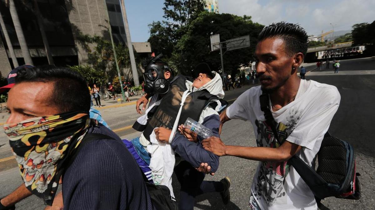 Un manifestante opositor es evacuado durante choques con las fuerzas de seguridad en Caracas este lunes.