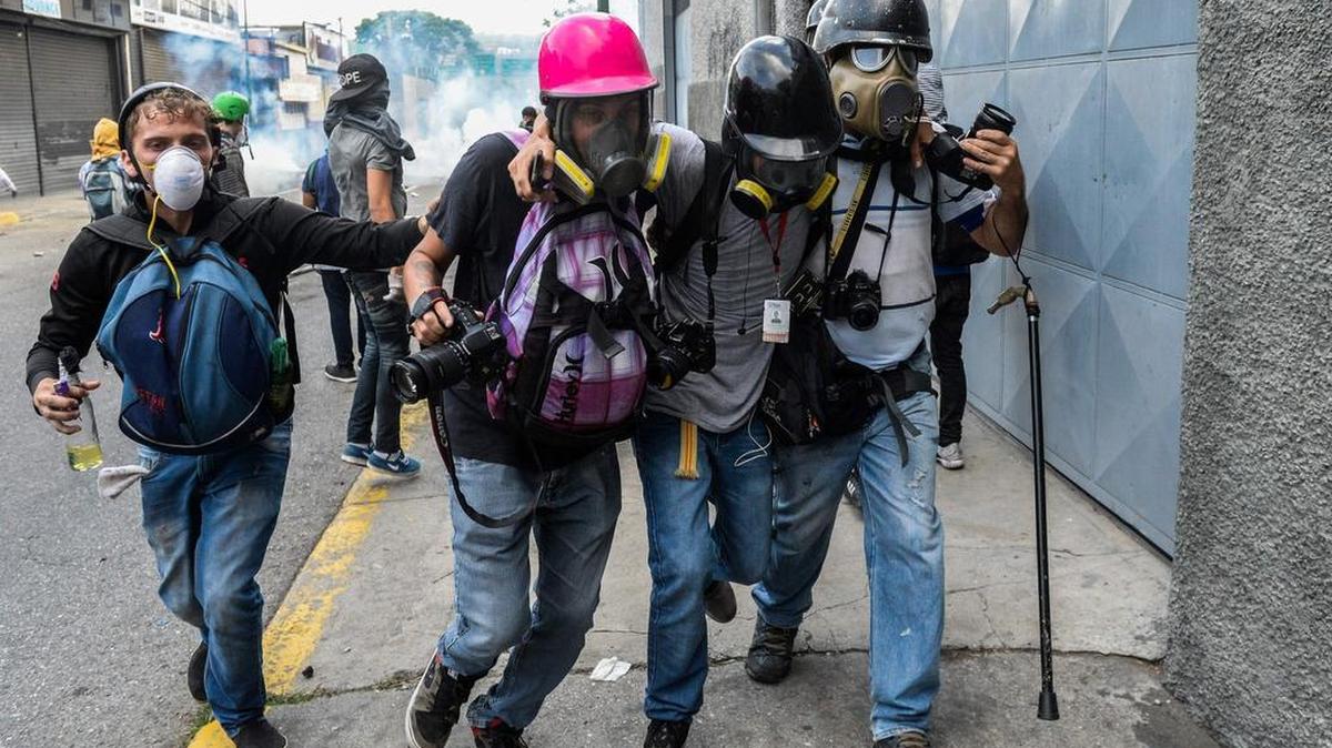 Un periodista agredido durante las protestas contra el gobierno de Nicolás Maduro es ayudado por varios colegas el lunes 10 de abril de 2017, en Caracas, Venezuela.