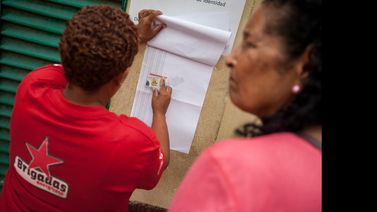 
Una mujer busca la mesa de votación para votar en un colegio electoral del oeste Caracas el sábado 28 de junio de 2015. 
